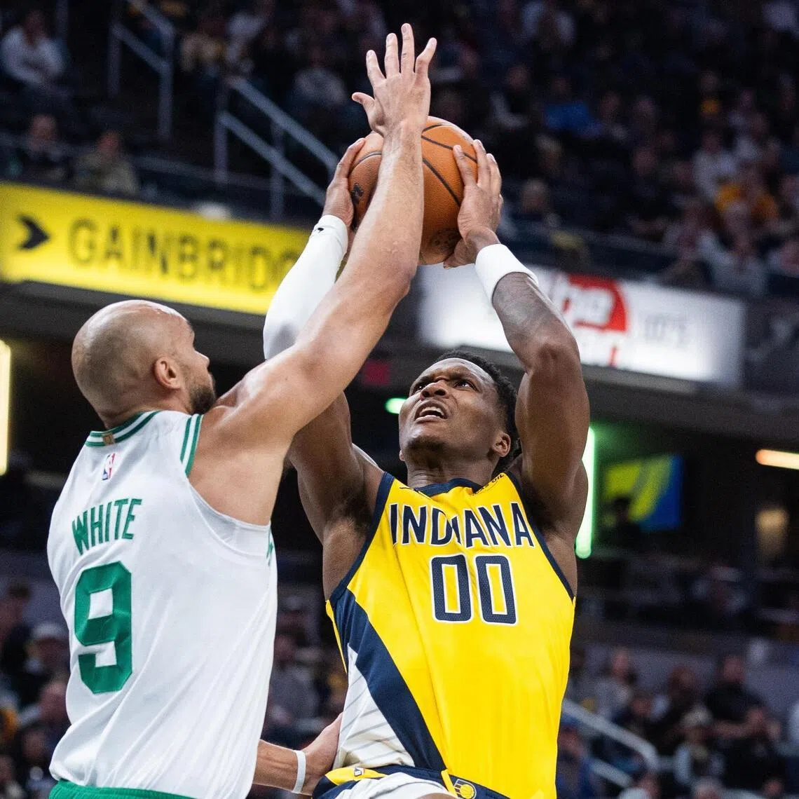Boston Celtics guard Derrick White defending Indiana Pacers guard/forward Bennedict Mathurin during the Celtics' 140-122 NBA win at Gainbridge Fieldhouse on Dec 26, 2025.
