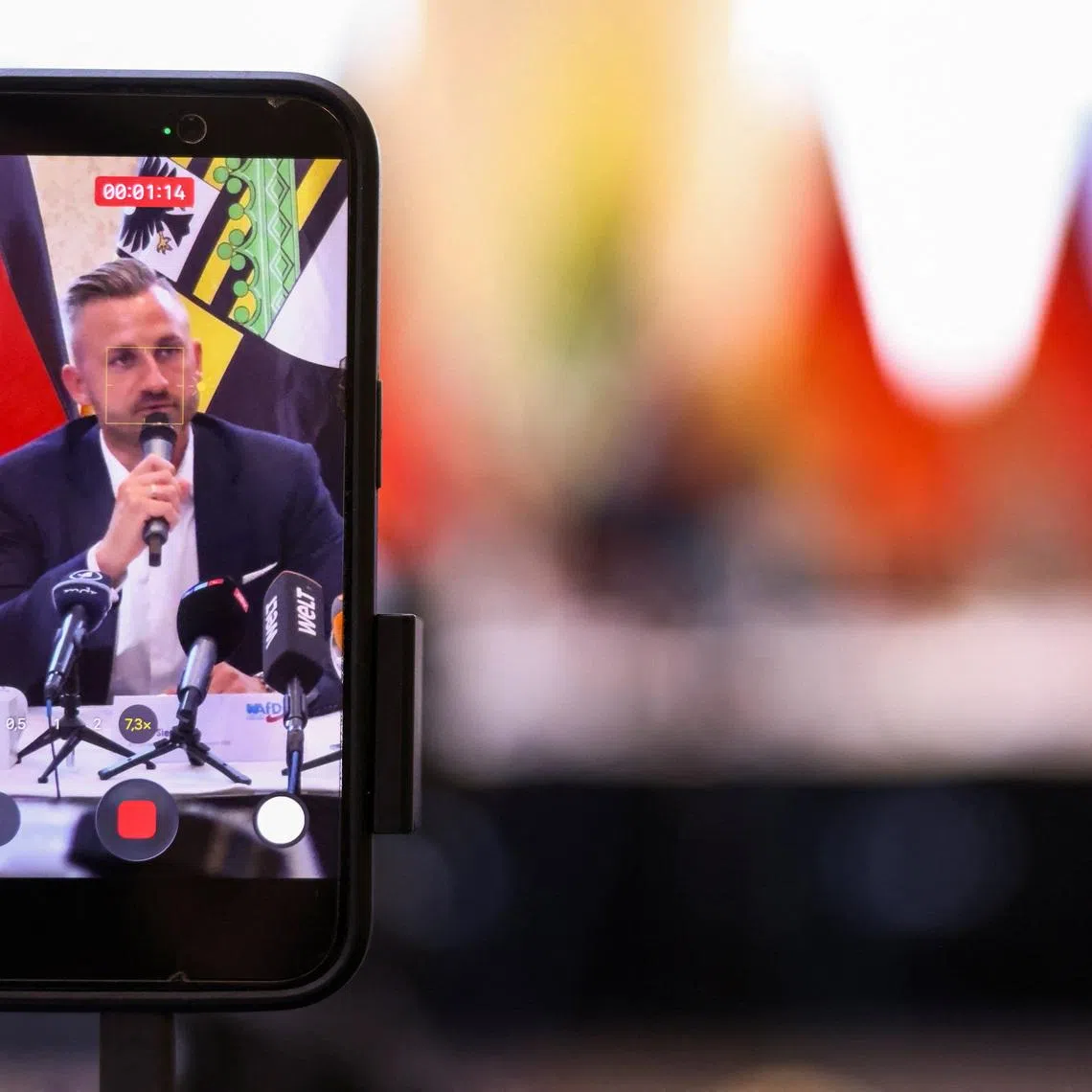 A person records with their phone, as Ulrich Siegmund, the top candidate of the far-right Alternative for Germany (AfD) party in Germany's Saxony-Anhalt state election, presents their election campaign and the activities of their top candidates for the September state election in Magdeburg, Germany, June 4, 2026. REUTERS/Liesa Johannssen