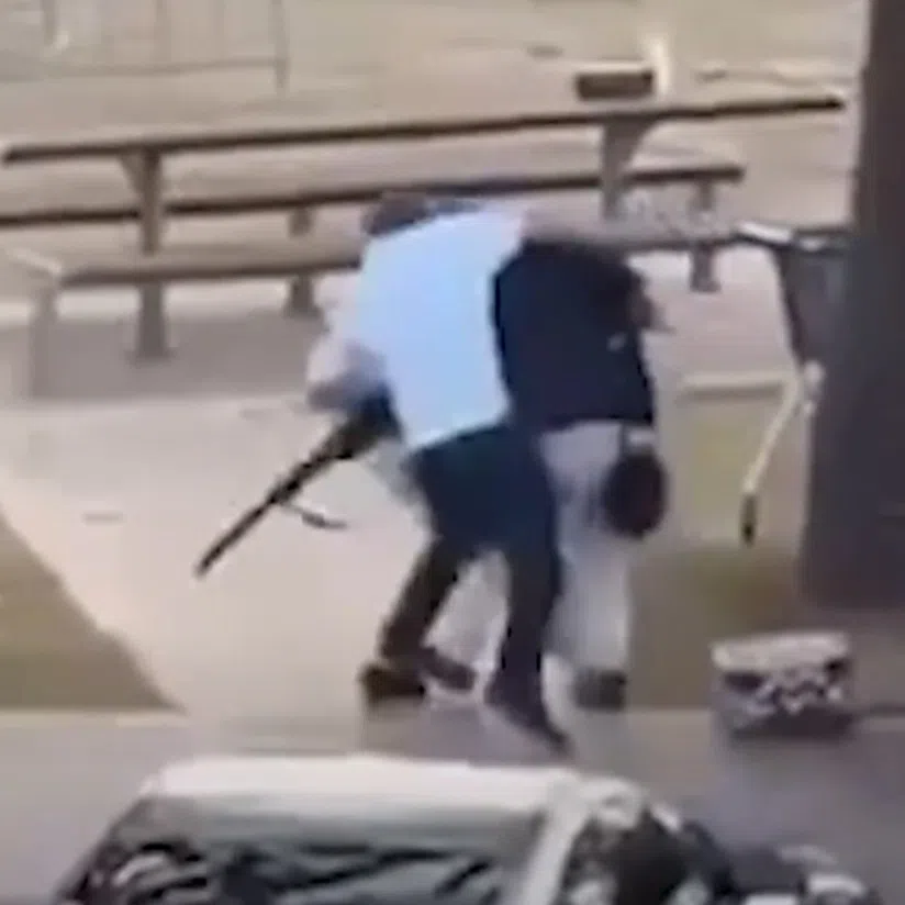 Footage circulating on social media shows a man ‍in a car park wearing a white shirt running up to a man in a dark shirt who is holding a rifle.