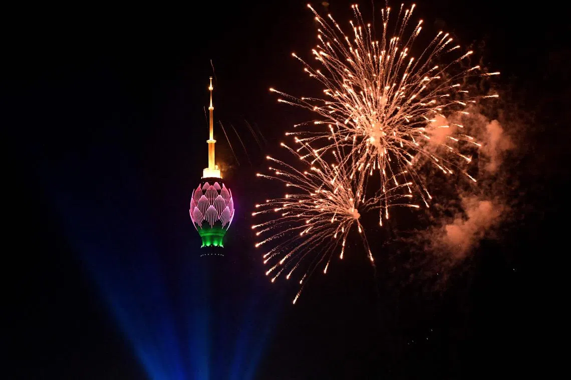 This photograph taken on Jan 1, 2023, shows fireworks in the sky next to the lit-up Lotus Tower during New Year celebrations in Colombo. 