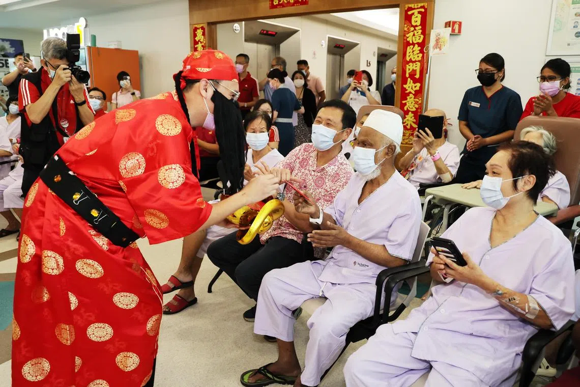 God of Wealth, played by Mr Benjamin Low, 34 , a nurse, giving red packets to patients with Mr Ong Ye Kung (third from right), Minister for Health, in attendance. Minister Ong was visiting Tan Tock Seng Hospital on the first day of the Chinese New Year on Feb 10, to express his appreciation to healthcare staff working to keep essential healthcare services running over the holiday.