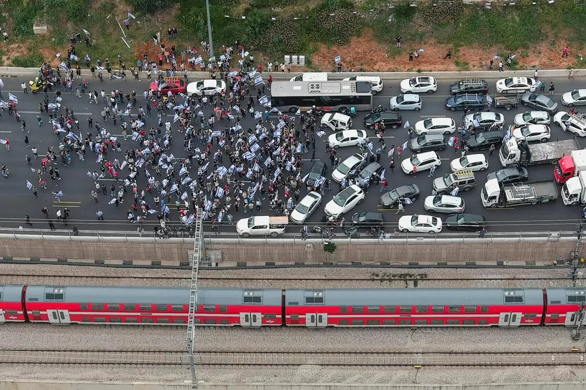 An aerial view showing demonstrators as they block a main road as part of a "Day of Shutdown" protest, as Israeli Prime Minister Benjamin Netanyahu's nationalist coalition government presses on with its judicial overhaul, in Tel Aviv, Israel March 23, 2023. 