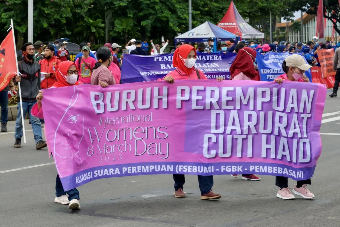 Women labour take part on a rally during International Women's Day near the Presidential palace in Jakarta on March 8, 2023, demanding menstrual leave for women who work as laborers. (Photo by BAY ISMOYO / AFP)