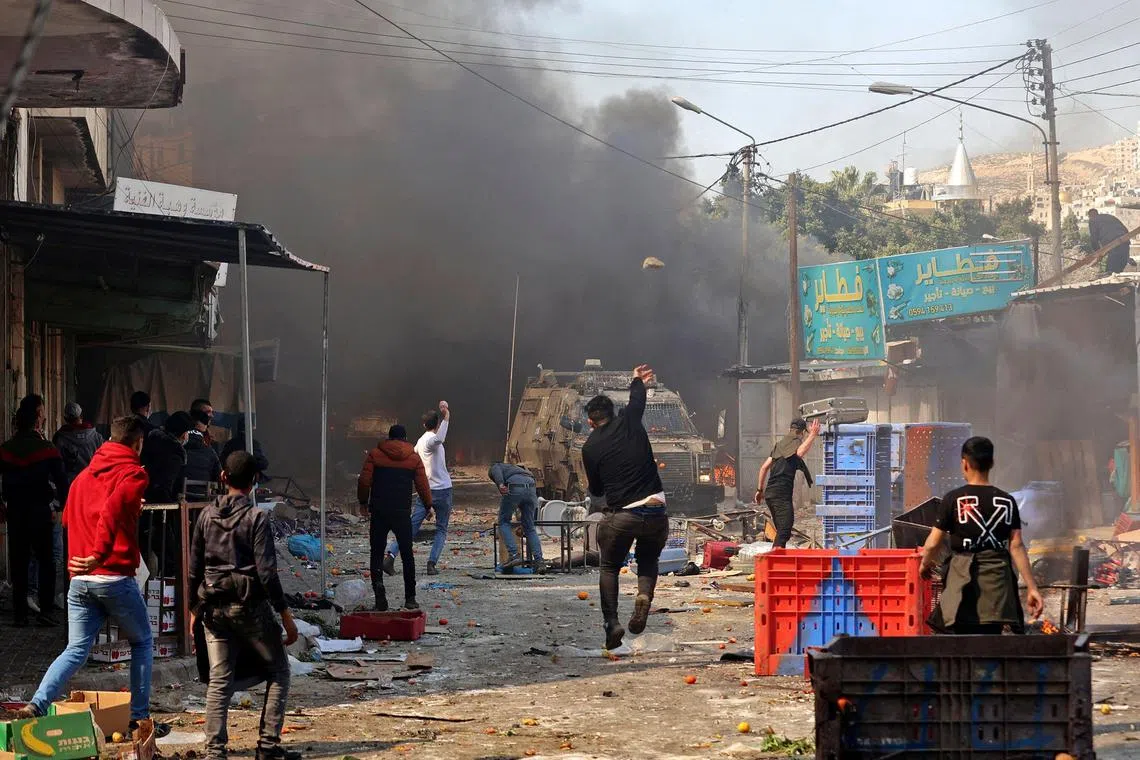 Palestinians clash with Israeli security forces, during a raid in the occupied West Bank city of Nablus, on Feb 22, 2023.