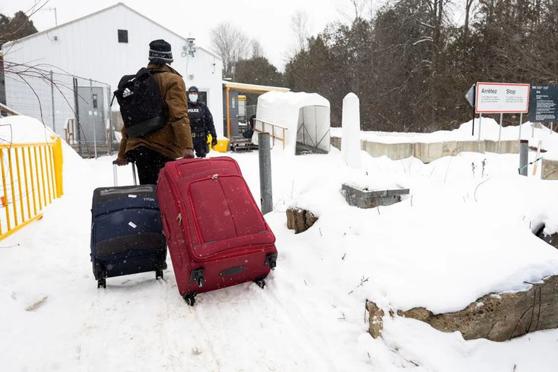 An asylum seeker arrives by taxi to cross into Canada from the U.S. border on Roxham Road in Champlain, New York, U.S., February 25, 2023. REUTERS/Christinne Muschi