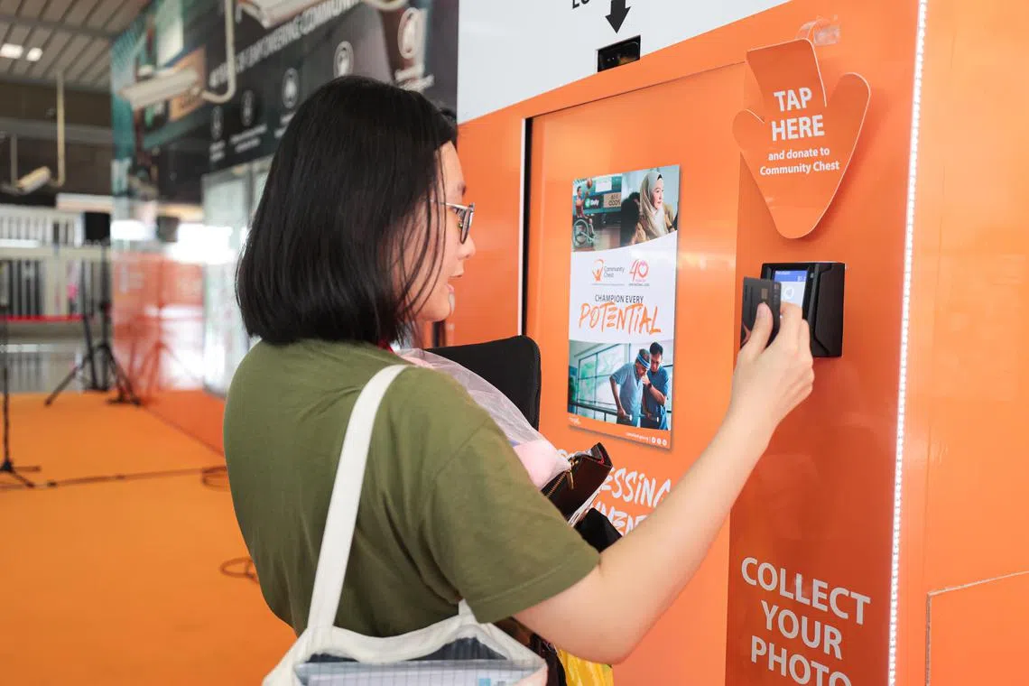 CMG20230913-JasonLee01/李冠卫/黄银川/Launch of Tap to Empower Lives Initiative	[Jurong East MRT Station Wall 9 (10 Jurong East Street 12, Singapore 609690)]

Members of the public using the tap and donate machine.