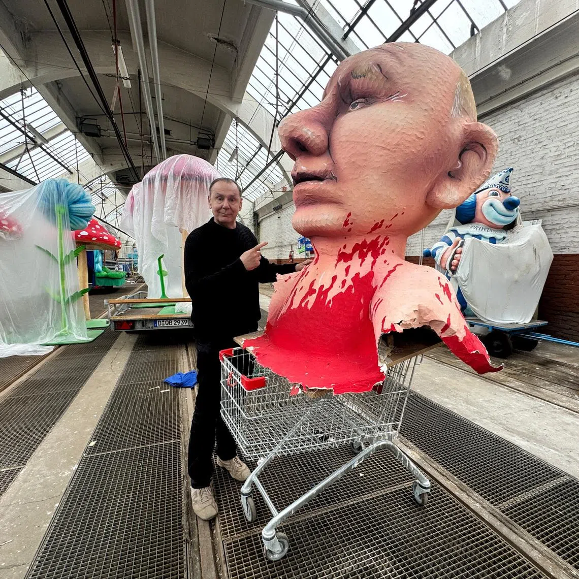 Jacques Tilly, a German sculptor and float builder famed for his provocative Carnival creations poses with a paper mache figure depicting Russian President Vladimir Putin in his workshop in Duesseldorf, Germany, April 2, 2026.    REUTERS/Petra Wischgoll