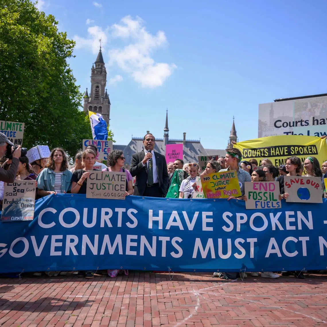 TOPSHOT - Vanuatu's Climate Change Minister Ralph Regenvanu (C) delivers a speech as he attends a demonstration ahead of the ICJ's reading of the advisory opinion in The Hague on July 23, 2025. 
