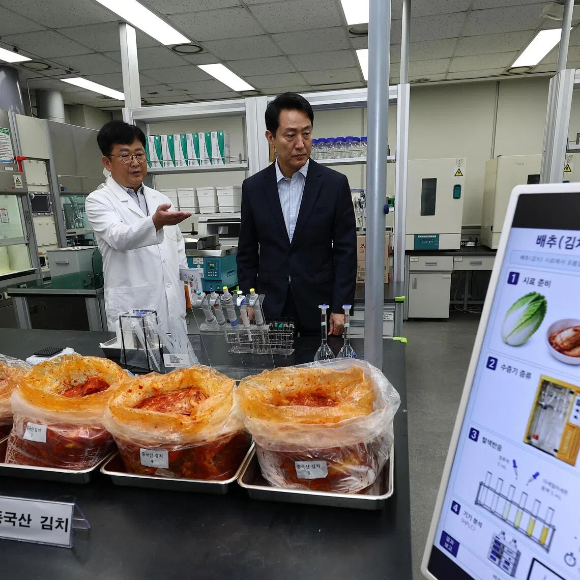 Seoul Mayor Oh Se-hoon (right) being briefed by Park Joo-seong, chief of the city-run Public Health and Environment Research Institute, on the special inspection of packaged cabbage kimchi imported from China, in Seoul on Aug 31.