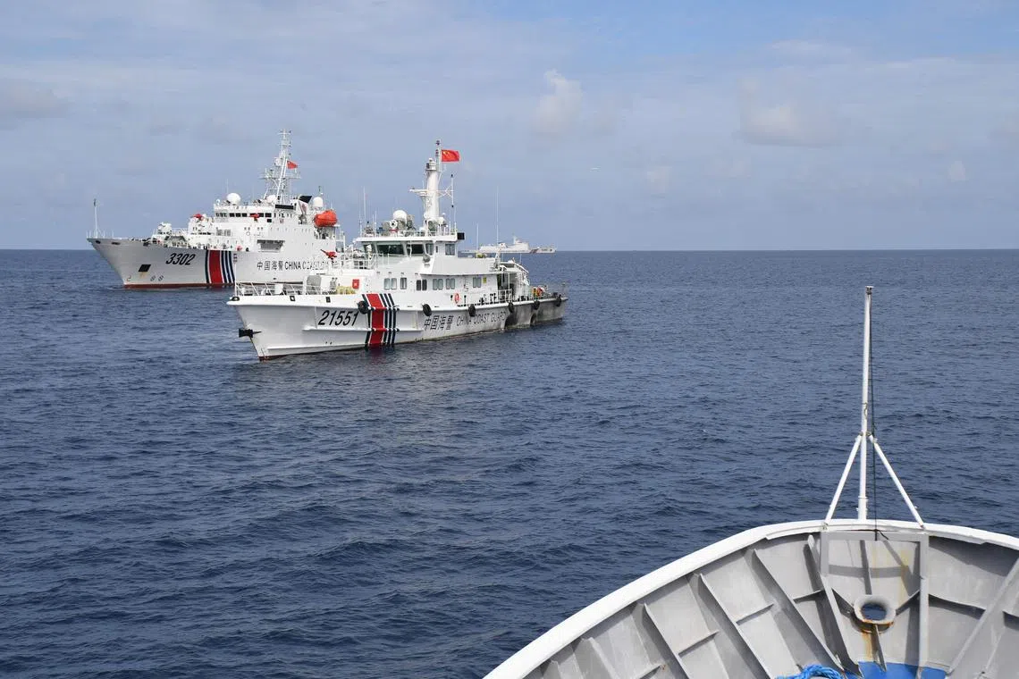 Chinese coast guard ships (left) blocking the path of a Philippine coast guard ship in the South China Sea on Aug 22.