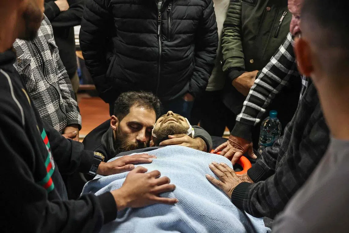 Palestinians mourning over the body of Mohammad Shahmawi following an army raid by Israeli forces in the al-Faraa camp in the occupied West Bank on April 12, 2024.