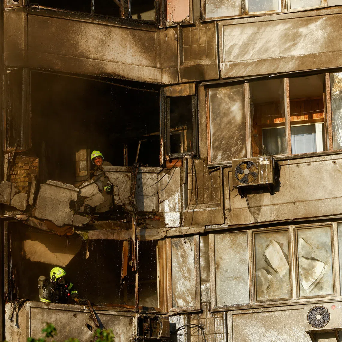 Firefighters work at the site of a residential building hit during a Russian jet-powered drone strike in Kyiv, Ukraine, on Sept 27.