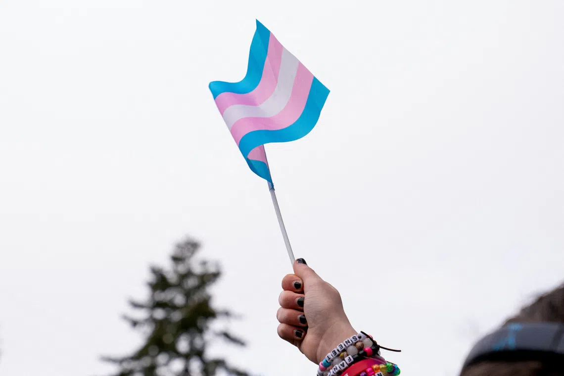 A demonstrator holds a trans flag during a rally in support of trans youth at Seattle Children’s hospital in Seattle, Washington, U.S. February 8, 2025. REUTERS/David Ryder