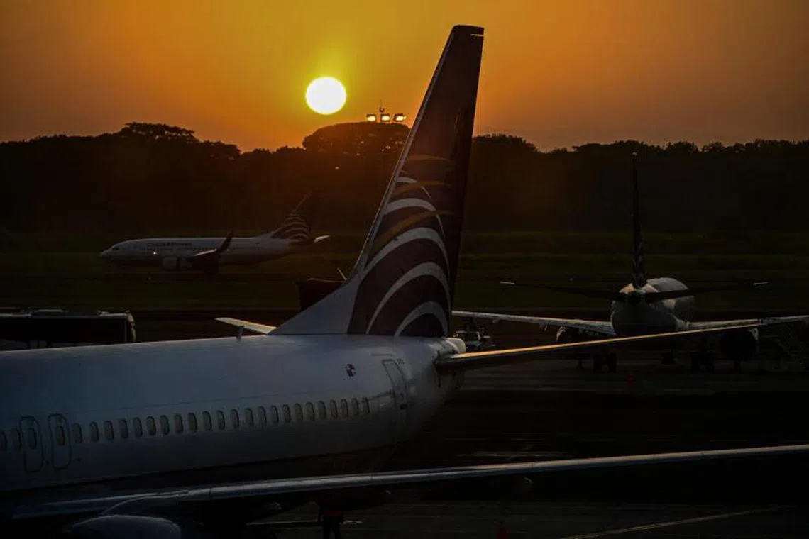 (FILES) Aircrafts of Panamanian carrier Copa Airlines are seen during sunrise at Tocumen International Airport in Panama City on January 12, 2024. Panama's civil aviation authority on May 22, 2025, announced that it would resume flights with Venezuela after nearly a year, facilitating the repatriation of Venezuelan migrants expelled from the United States. (Photo by Martin BERNETTI / AFP)