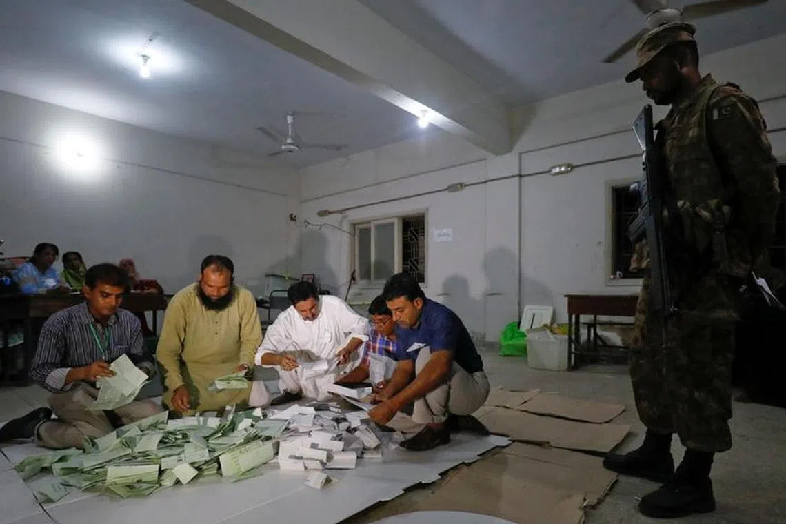 FILE PHOTO: Election officials count votes after polling stations closed during the general election in Karachi, Pakistan, July 25, 2018.  REUTERS/Akhtar Soomro/File Photo