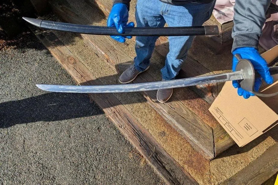 A law enforcement agent holds one of several bladed weapons seized by authorities after the arrest of Andrew Emerald in Great Barrington, Massachusetts, U.S., April 1, 2026, on charges that he threatened U.S. President Donald Trump in Facebook posts. U.S. Attorney's Office for the District of Massachusetts/Handout via REUTERS