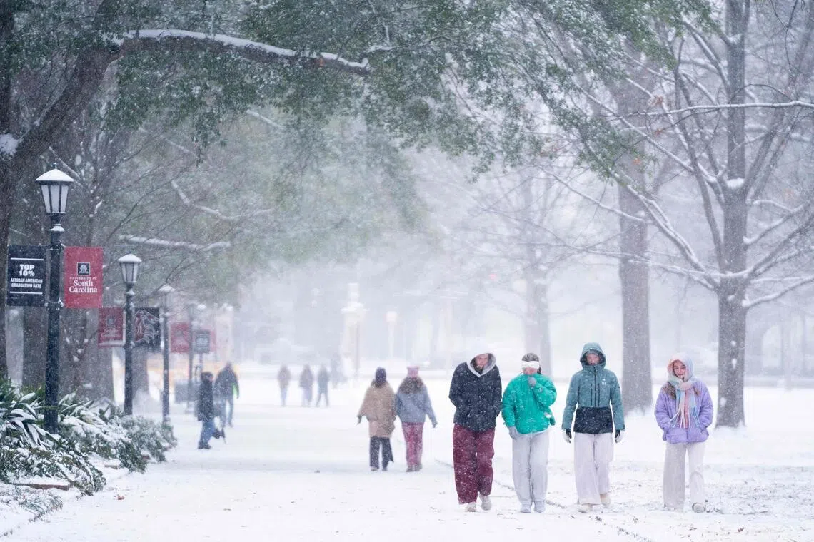 Students walk across the historic Horseshoe as snow falls at the University of South Carolina on Jan 31.