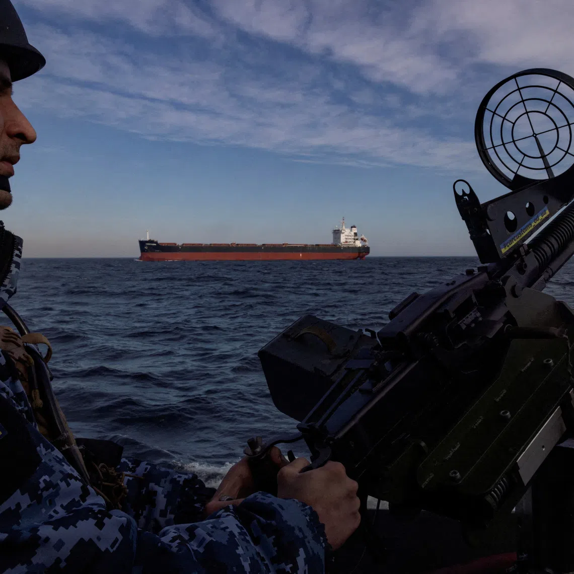 FILE PHOTO: A serviceman in Ukraine's coast guard mans a gun on a patrol boat as a cargo ship passes by in the Black Sea, February 7, 2024. REUTERS/Thomas Peter/File Photo