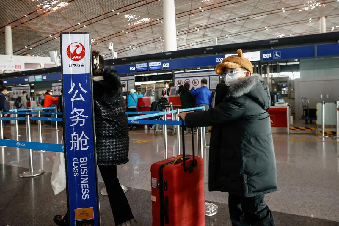 Passengers line up at the check-in counter of Japan Airlines inside the Beijing Capital International Airport in Beijing, China, on Jan 1, 2023. 