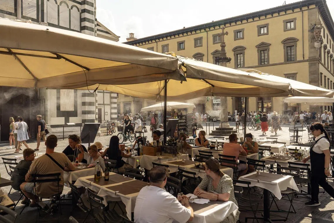 A restaurant uses water mist to cool patrons from the heat in Florence, Italy, on July 13.