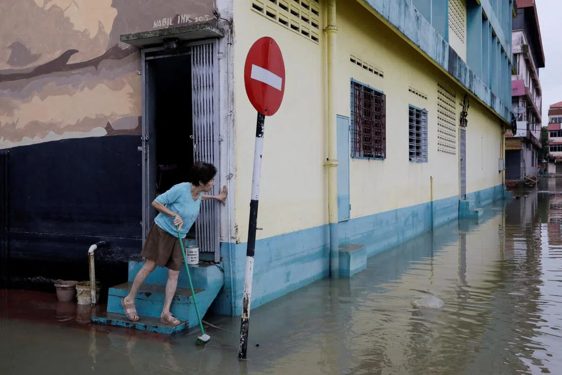 A woman checks the surrounding of her shophouse, as the floodwaters recede, in Kota Tinggi, Johor, Malaysia, March 5, 2023. 
