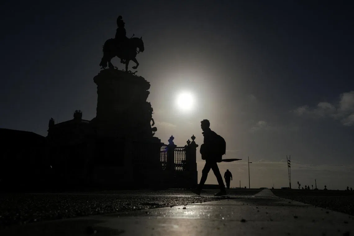 People walk early in the morning in Terreiro do Paco, Lisbon, Portugal, October 25, 2022. REUTERS/Pedro Nunes/File Photo