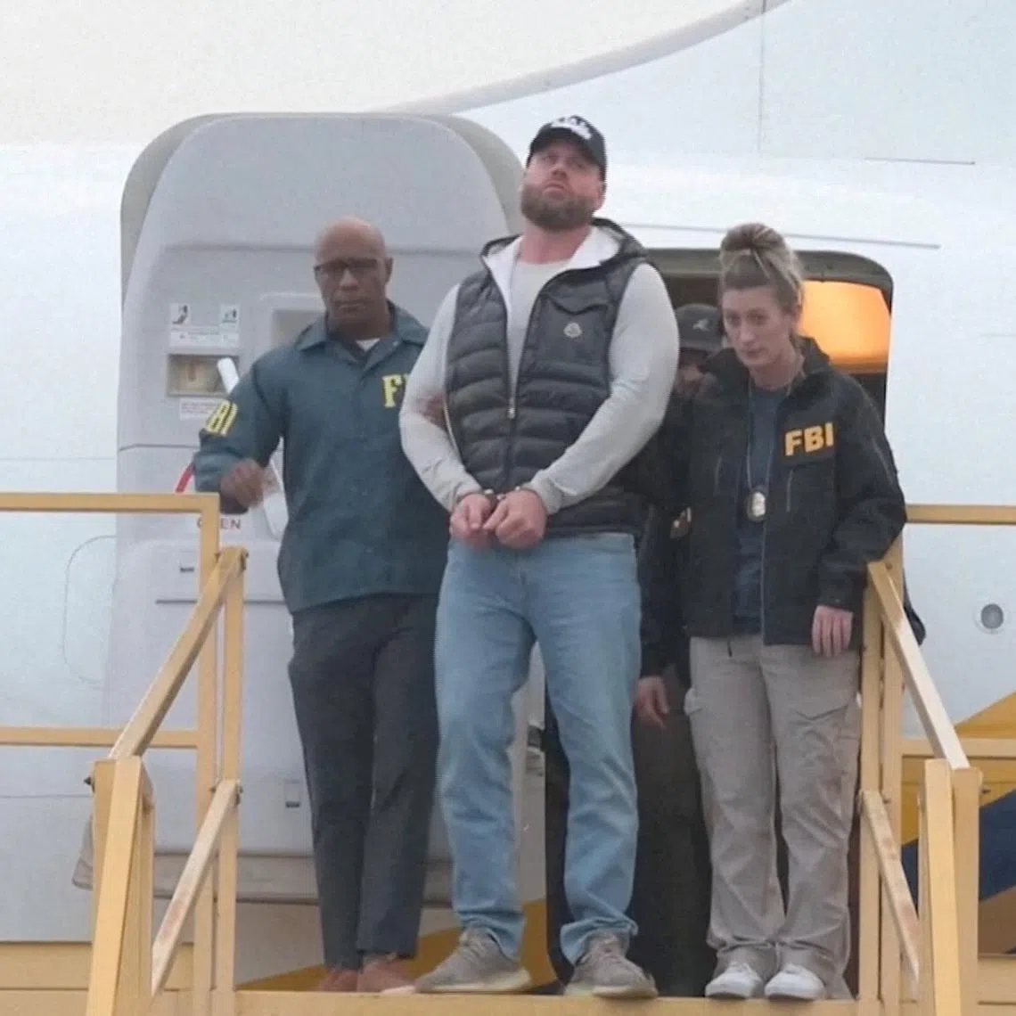 Ryan Wedding, a Canadian former Olympic snowboarder accused of becoming a cocaine smuggling kingpin linked to multiple drug-related murders, is escorted by FBI agents as he arrives handcuffed at Ontario International Airport, in California, U.S., January 23, 2026, in this screengrab taken from video.  FBI/Handout via REUTERS