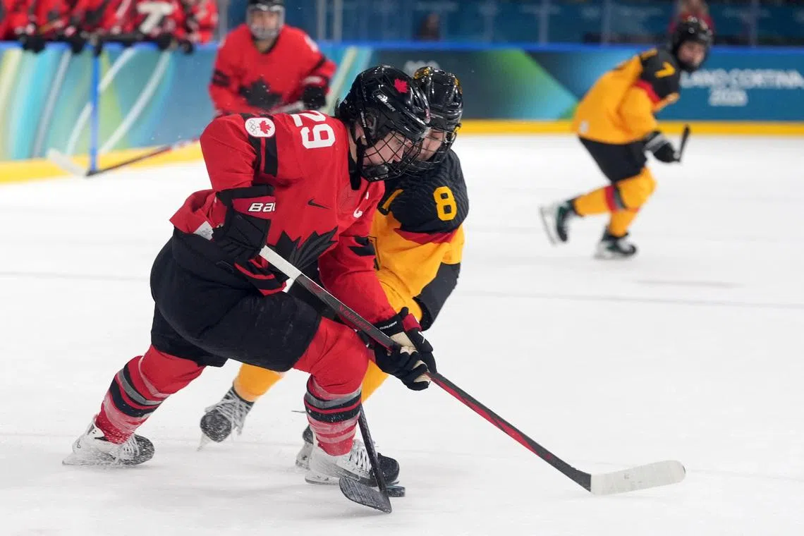 Milano Cortina 2026 Olympics - Ice Hockey - Women's Play-offs Quarterfinals - Canada vs Germany - Milano Rho Ice Hockey Arena, Milan, Italy - February 14, 2026. Marie-Philip Poulin of Canada in action with Ronja Hark of Germany. IMAGN IMAGES via REUTERS/Amber Searls