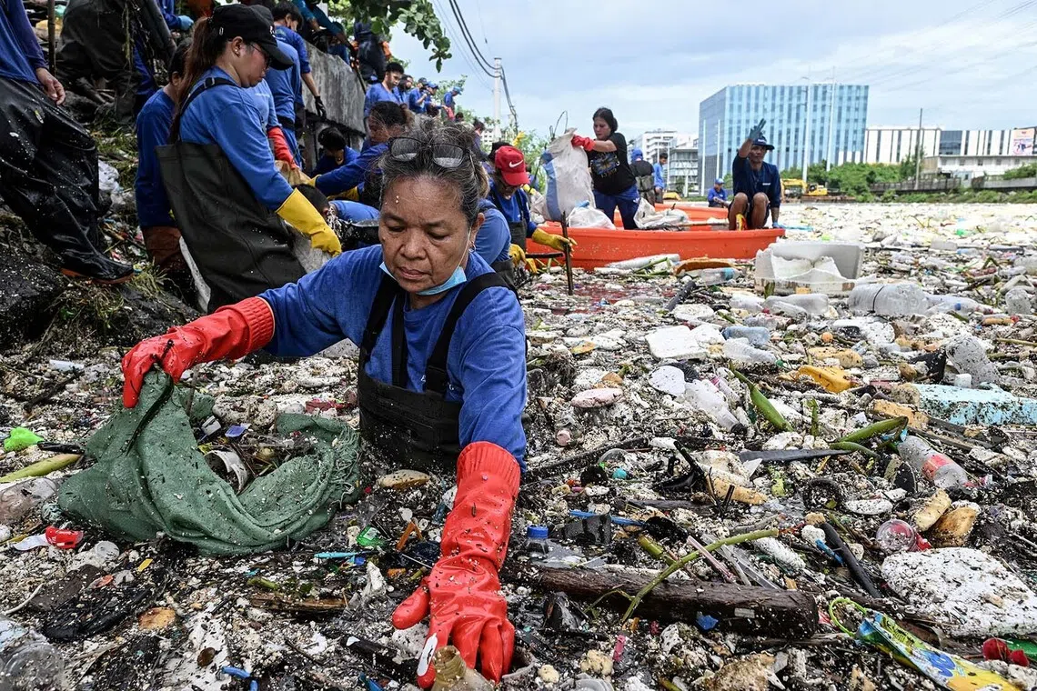 Eva Mangunay, 62, part of the Department of Environment and Natural Resources (DENR), "Estero (canal) Rangers," collects garbage that washed into a river amid heavy southwest monsoon rains near Baclaran Church in Paranaque City, Metro Manila, Philippines, August 11, 2026. REUTERS/NOEL CELIS TPX IMAGES OF THE DAY