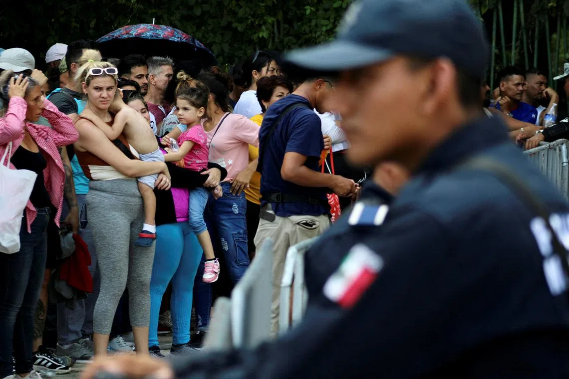 FILE PHOTO: Migrants gather outside an office of Mexico's Refugee Aid Commission to obtain a humanitarian visa that allows them safe passage to continue their journey to Mexico's northern border to seek asylum in the U.S., in Tapachula, Mexico September 25, 2023. REUTERS/Jose Torres/File Photo