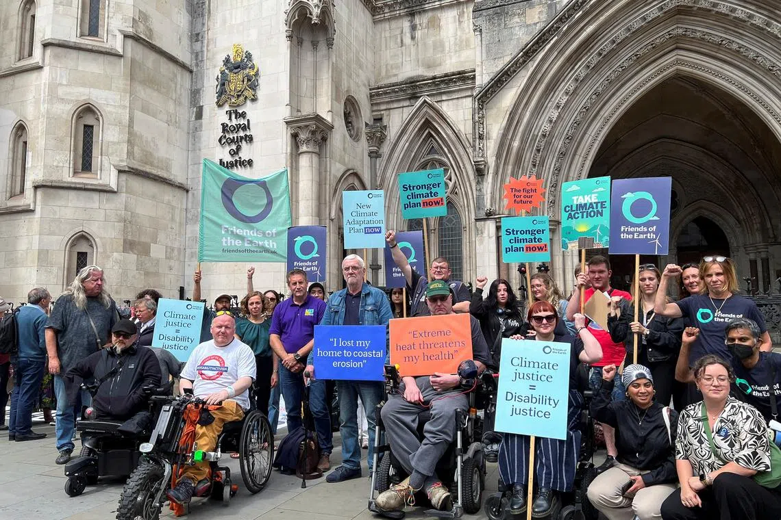 Supporters of environmental group Friends of the Earth hold signs outside the Royal Courts of Justice, during their legal challenge at the High Court, in London, Britain July 23, 2024. REUTERS/Sam Tobin