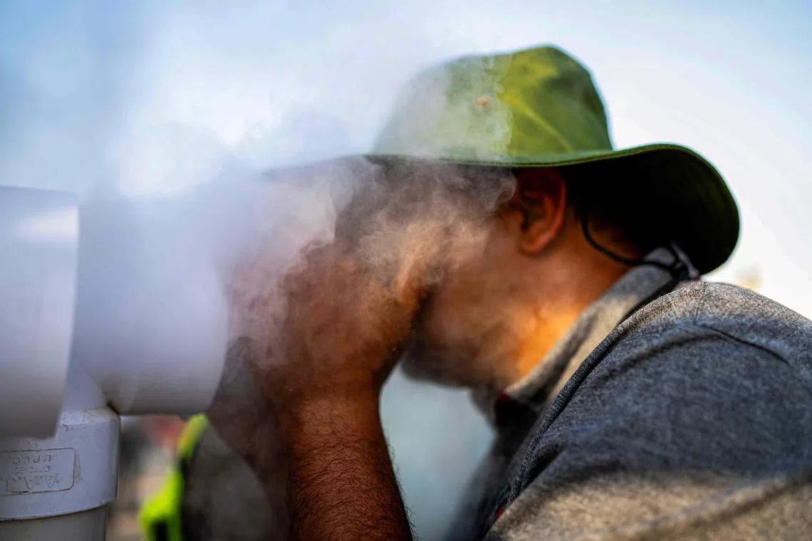An Iraqi man cooling off as Shiite Muslim pilgrims make their way towards Karbala through Basra on July 28, 2025. Iraqis grappled on July 28 with searing heat in the capital Baghdad and parts of the country's south, where the weather service said temperatures reached 51 deg C in the shade.