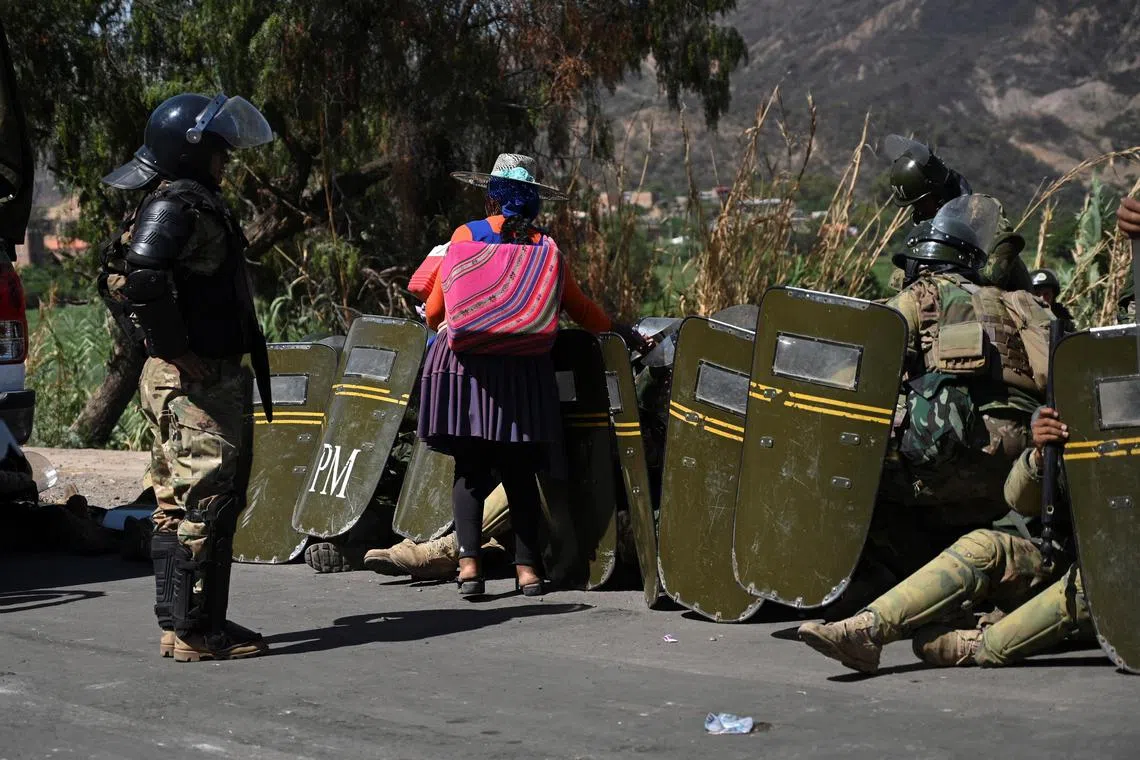 A woman sells ice cream to soldiers on guard as supporters of former President Evo Morales block key roads in Parotani, Cochabamba, Bolivia on Nov 1.