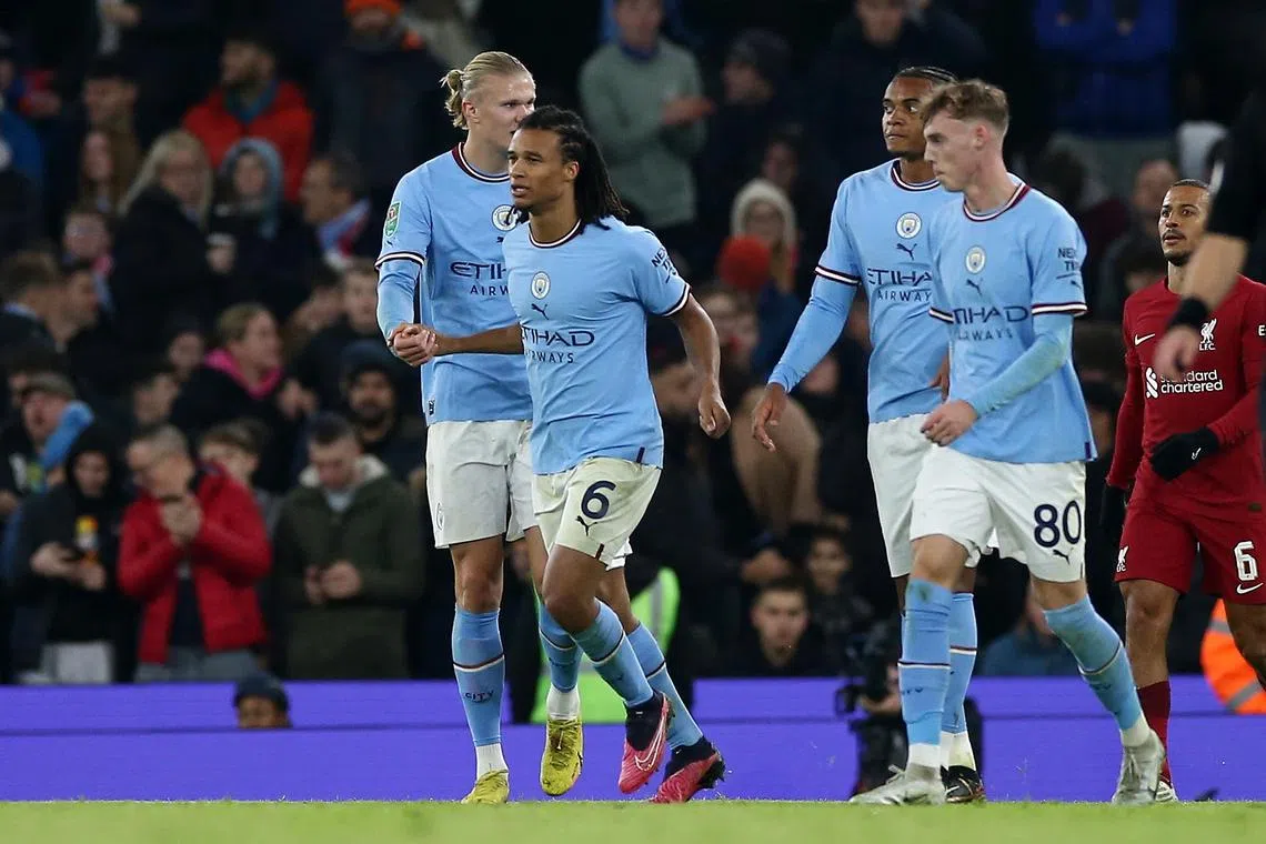 Nathan Ake (second from left) celebrates with Erling Haaland (left) after scoring City's winning goal.