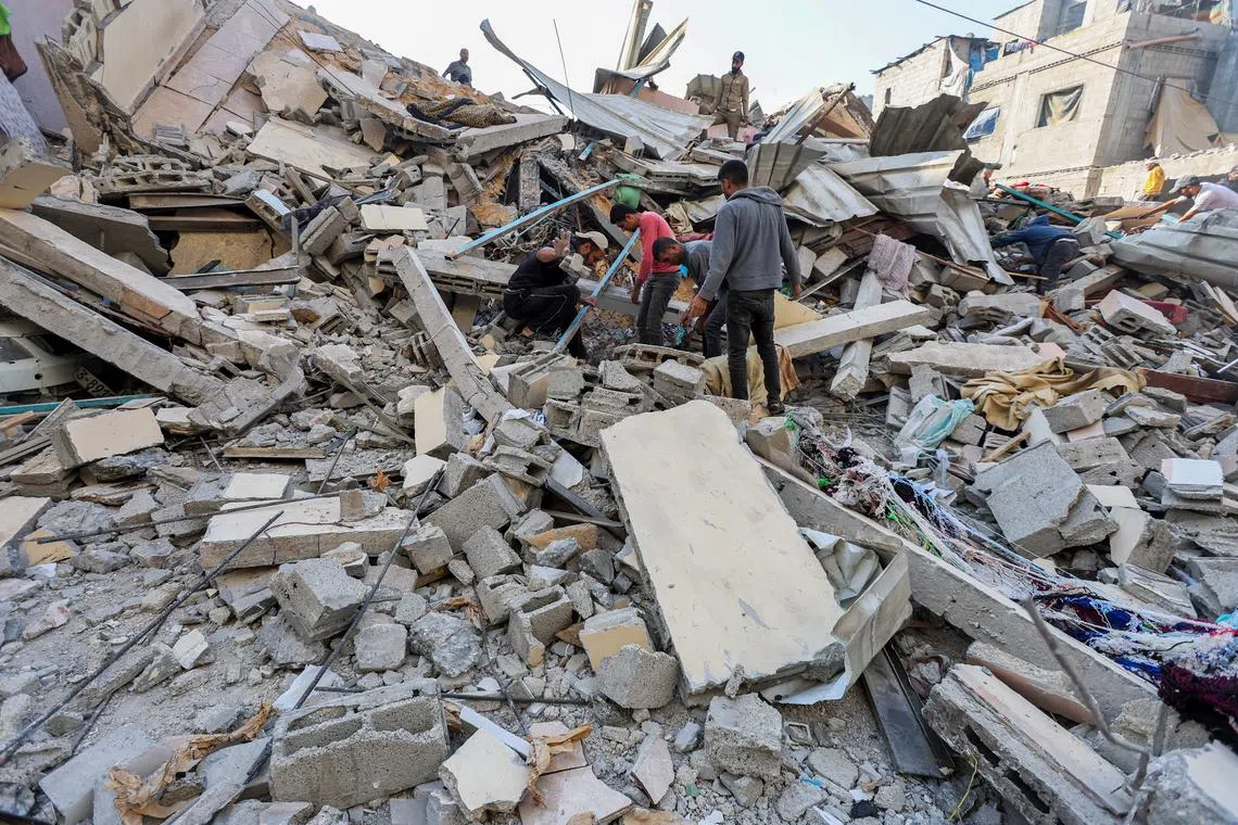 FILE PHOTO: Palestinians search for casualties at the site of an Israeli strike on a house, amid the ongoing conflict between Israel and the Palestinian Islamist group Hamas, in Nuseirat refugee camp in the central Gaza Strip, May 14, 2024. REUTERS/Ramadan Abed/File Photo