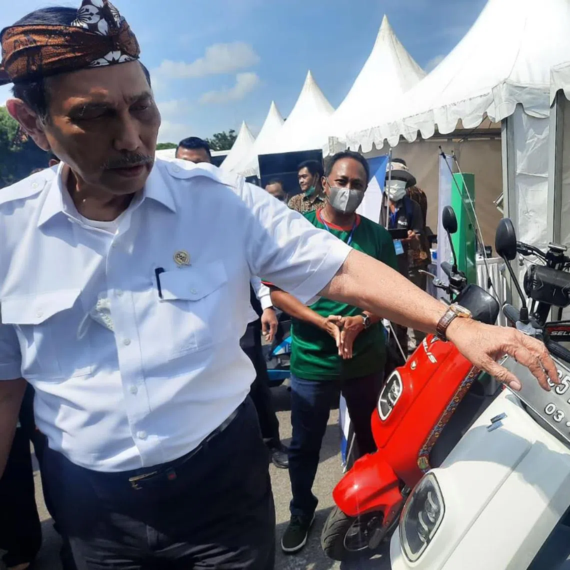 Indonesia's coordinating minister for maritime affairs and investment Luhut Pandjaitan, posing with one of PT Juara Bike's E-Max electric two wheelers last year.
