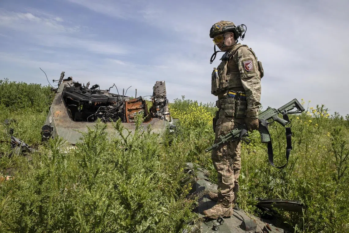 A Ukrainian soldier checks out destroyed Russian armoured vehicles in the front-line village of Novomykhailivka, in Ukraine's Donetsk region.