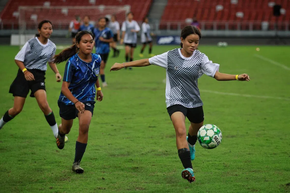 Methodist Girls’ School's Chloe Koh, 15, (right) fires her school into the lead against Woodlands Secondary during the girls’ 8v8 match of School Football Academy Fiesta at the National Stadium on Saturday.