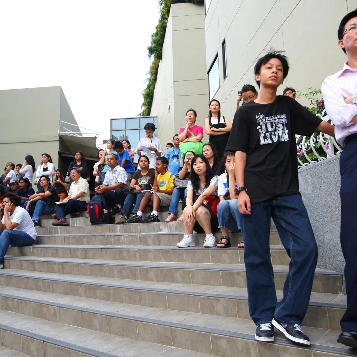 Fans watching the Formula One SingTel Singapore Grand Prix 2008 practice session at an outdoor staircase across from the Esplanade at Marina Square.