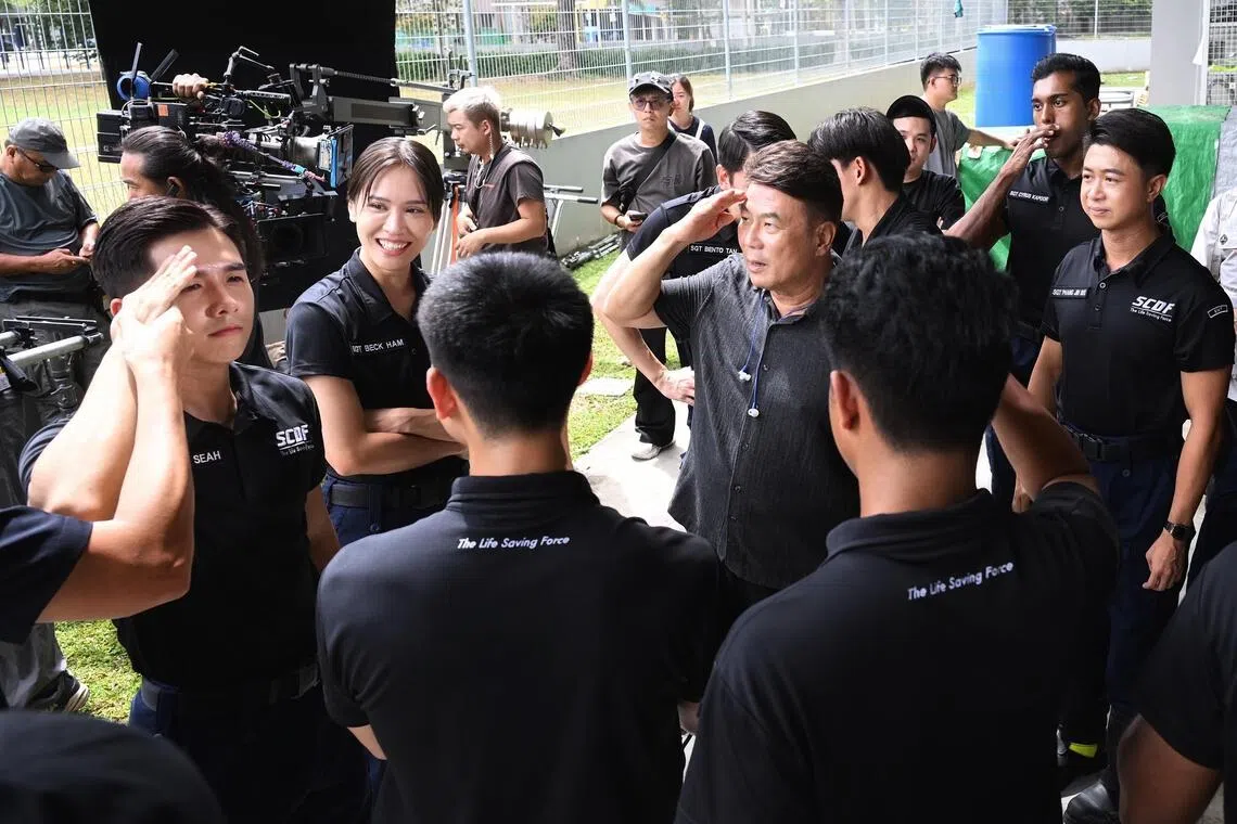 Jack Neo (second from right) directing his cast during the filming of Ah Boys To Firefighters at the Punggol Fire Station.