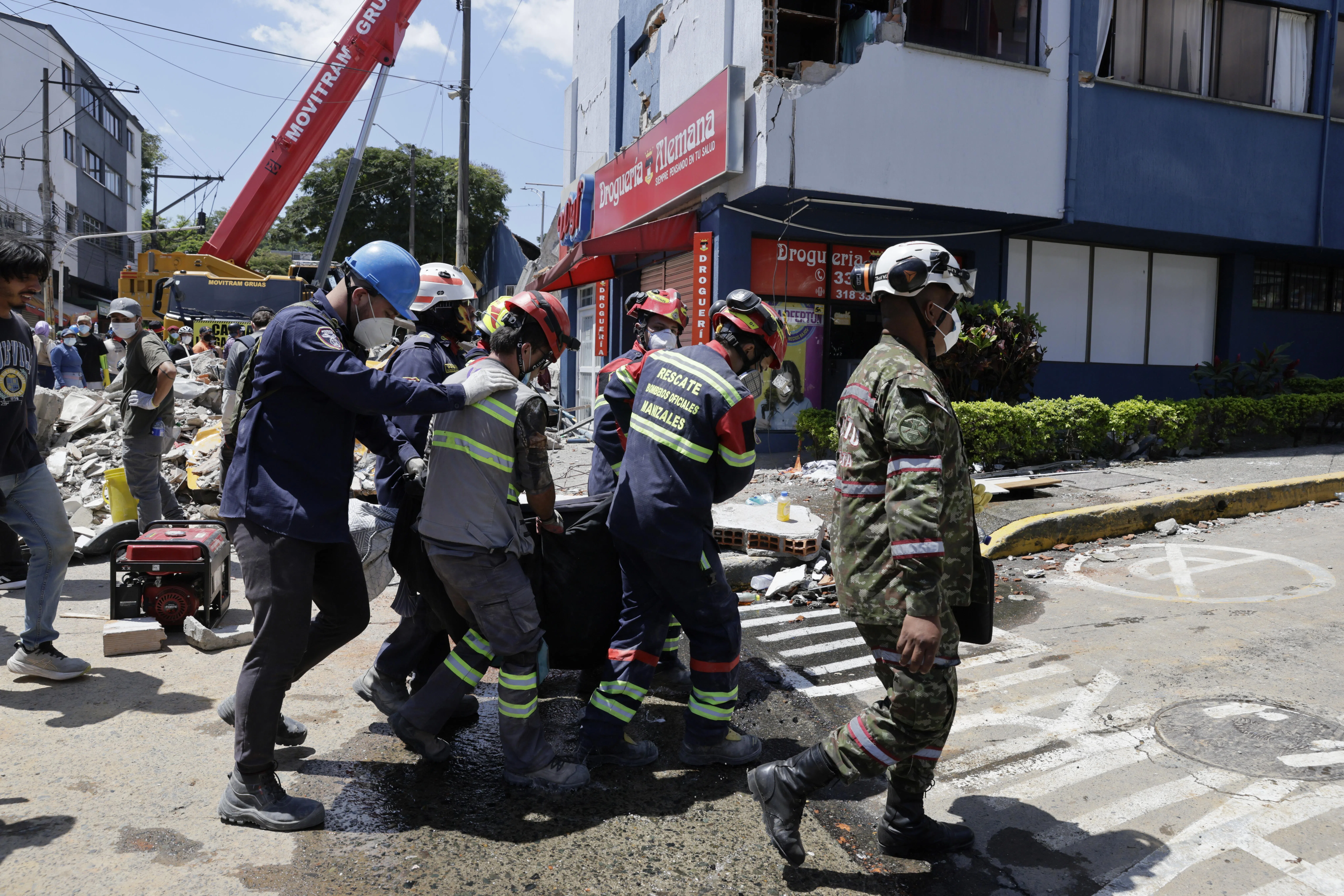 Rescuers carrying the body of a victim recovered from the rubble of a building in Pereira, Colombia, on Aug 11.