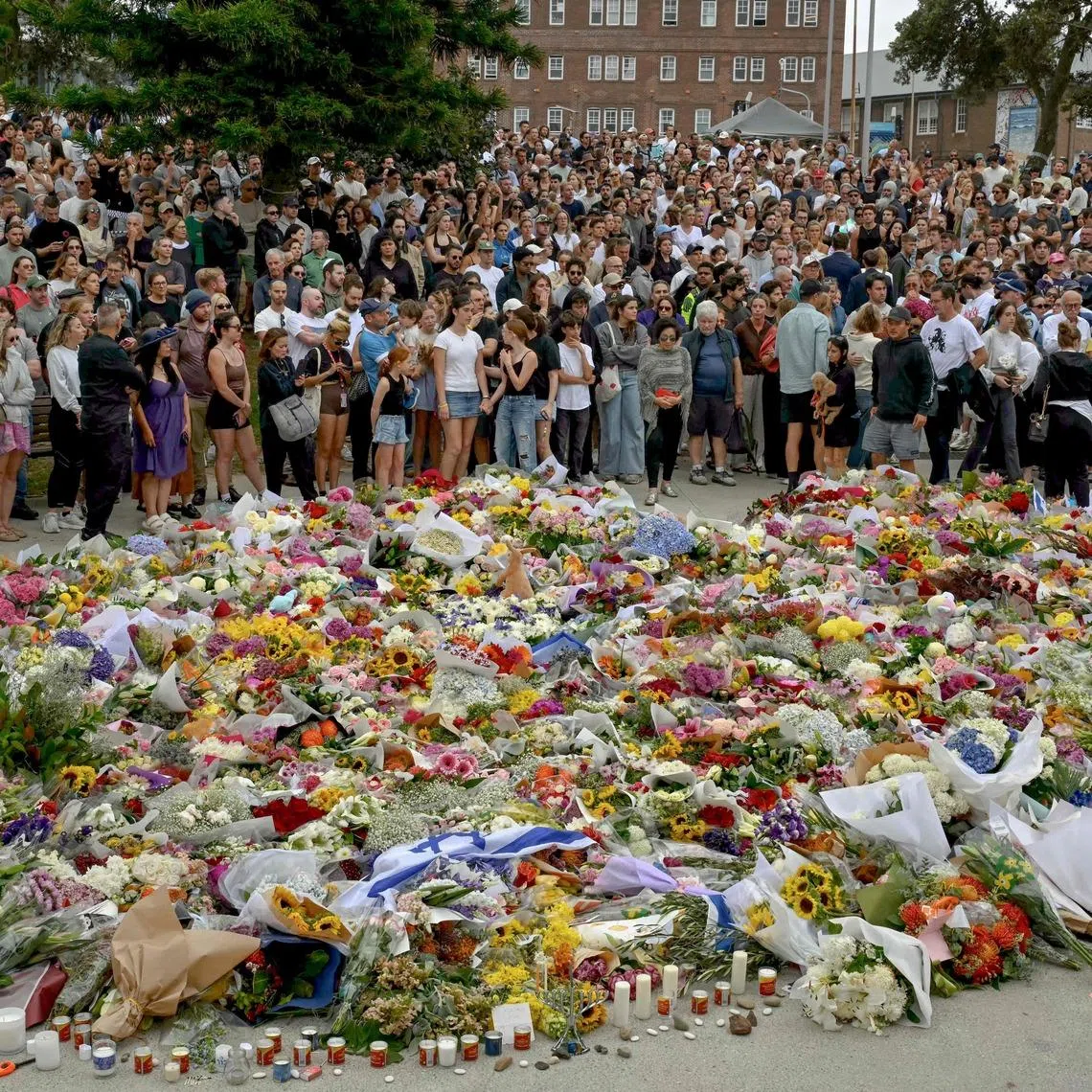 Mourners gather by floral tributes at the Bondi Pavillion in memory of the victims of a shooting at Bondi Beach in Sydney. 