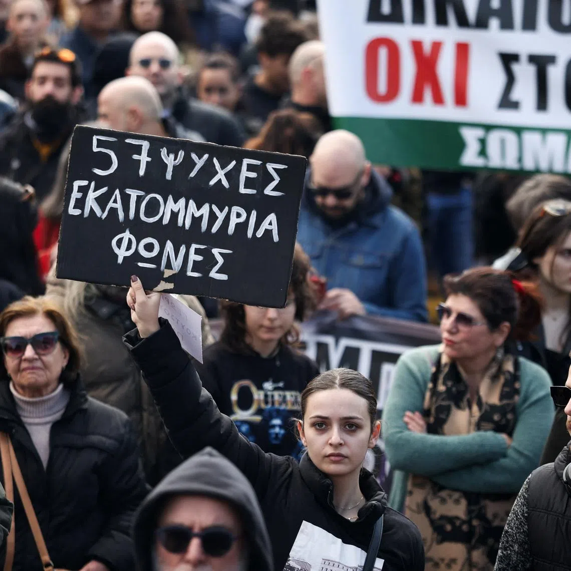 A protester holds a placard during a demonstration in front of the Greek parliament, marking the third anniversary of the 2023 deadly train crash in Tempi, the country's worst railway disaster on record, in Athens, Greece, February 28, 2026. REUTERS/Louisa Gouliamaki