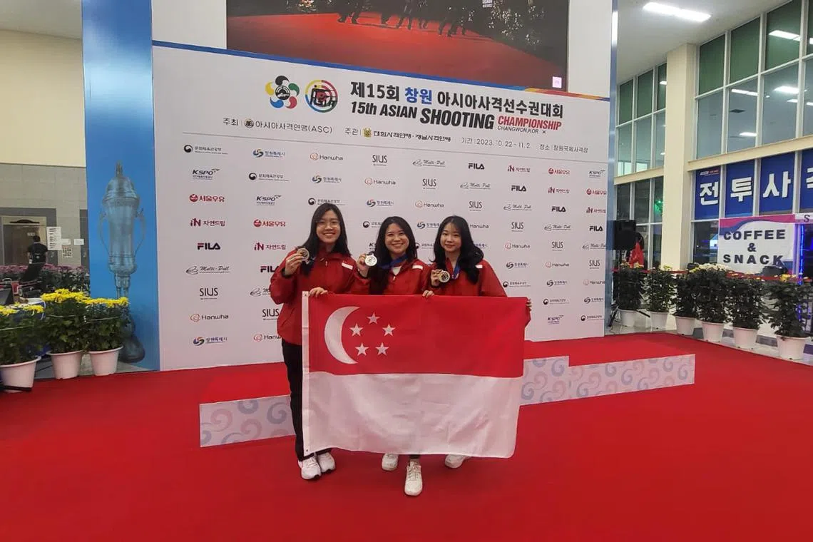 dgshoot27 - From left: Singapore shooters Fernel Tan, Martina Veloso and Natanya Tan won a silver medal in the 10m air rifle women's team event at the Asian shooting championships in Changwon on Friday.

