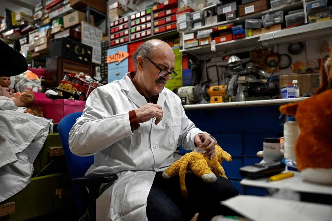Antonio Martinez Rivas, 70 years old, sews a "Lion King" soft toy at his workshop "Hospital del Juguete" (Toys hospital), in Madrid on December 20, 2022. - The father of Antonio Martinez Rivas opened a small shop of hand-made toys in 1945 before turning increasingly to repairs following the mass influx of plastic toys in the 1950s and 60s. The "toy hospital" is about to close its doors after 50 years of repairs. (Photo by OSCAR DEL POZO / AFP)