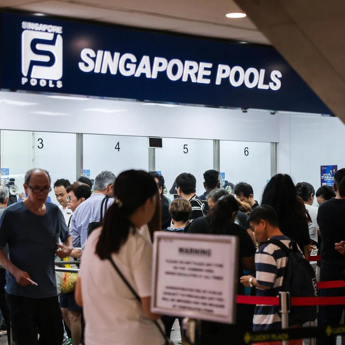 People queue for Toto at the Singapore Pools branch in Lucky Plaza on Nov 6, 2025. 