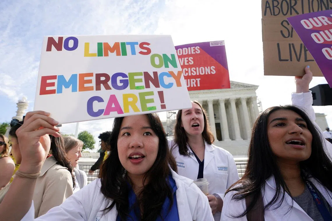 FILE PHOTO: Abortion rights supporters hold placards on the day the Supreme Court justices hear oral arguments over the legality of Idaho's Republican-backed, near-total abortion ban in medical-emergency situations, at the U.S. Supreme Court in Washington, U.S., April 24, 2024. REUTERS/Kevin Lamarque/File Photo