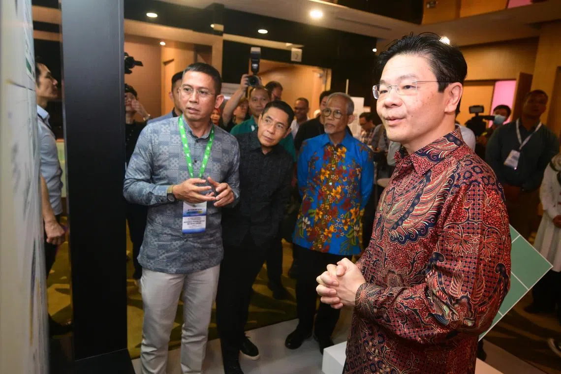 PM Lawrence Wong with (second from left) Dr Mohamad Maliki Osman, Second Minister for Education, and Mr Masagos Zulkifli, Minister-in-charge of Muslim Affairs, during a tour around the exhibition on Nov 10.