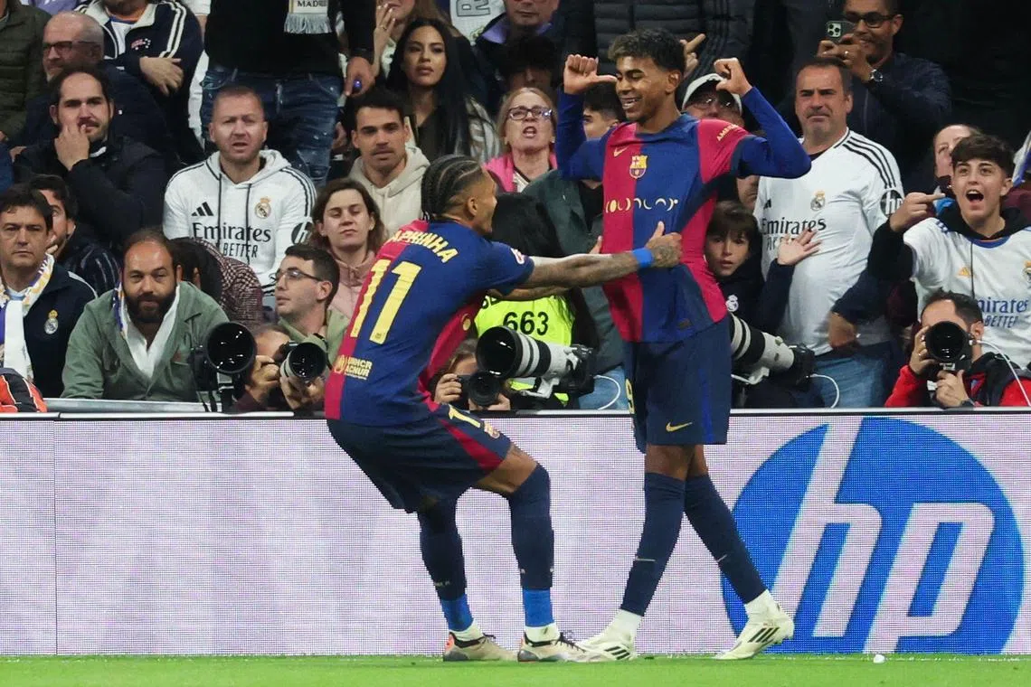 Lamine Yamal (right) celebrates scoring their third goal against Real Madrid with Raphinha at the Santiago Bernabeu stadium on Oct 26, 2024.
