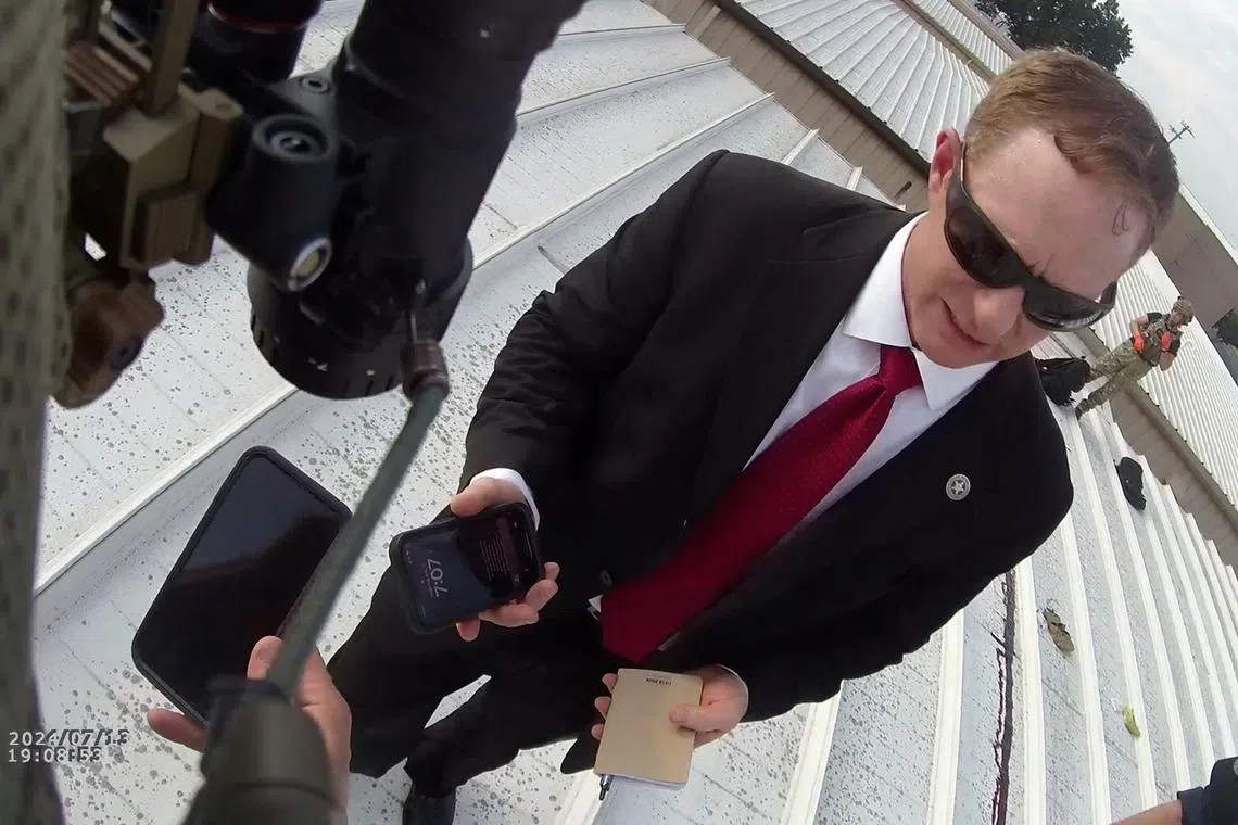 An investigator speaks with law enforcement officers near the body of a gunman on a roof after the assassination attempt on former President Donald Trump during a campaign rally, in Butler, Pennsylvania, U.S., July 13, 2024 in this still image taken from bodycam video. Beaver Co Emergency Services Unit via Chuck Grassley/Handout via REUTERS